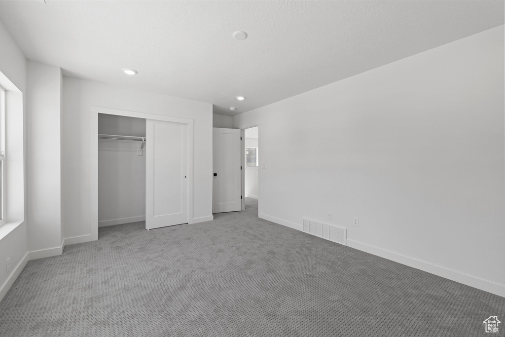 Unfurnished bedroom with carpet, a closet, baseboards, and recessed lighting