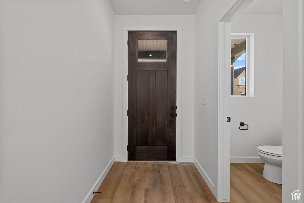 Foyer entrance with wood finished floors and baseboards
