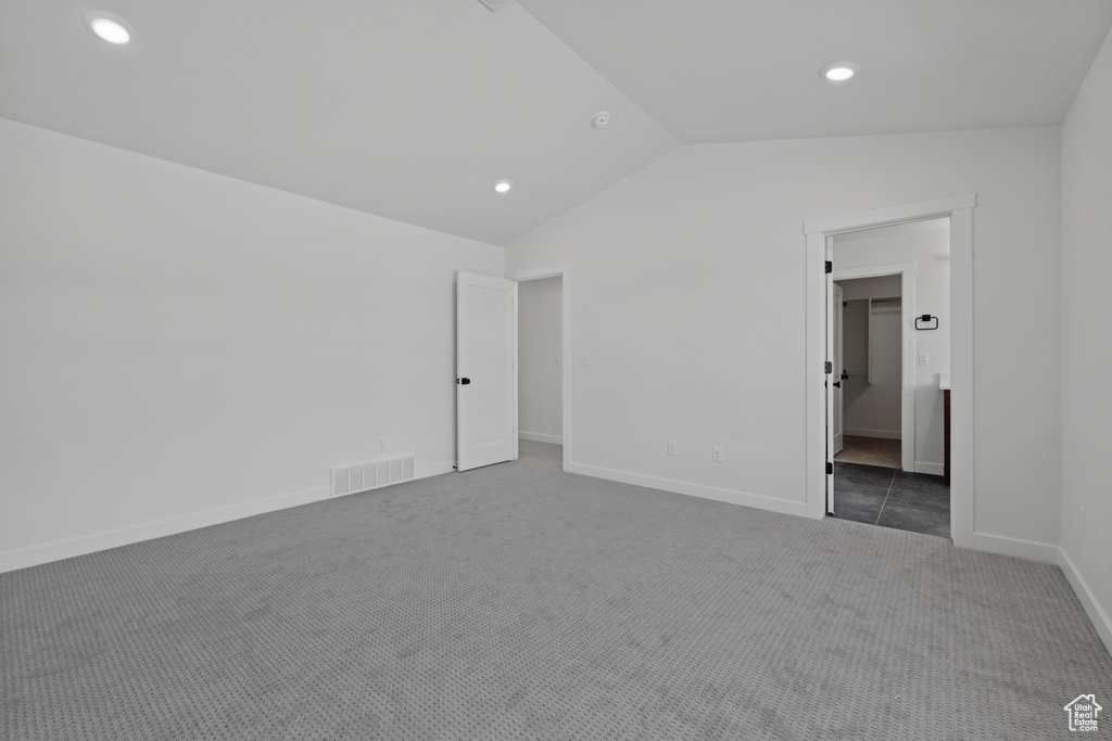 Unfurnished bedroom featuring carpet, lofted ceiling, recessed lighting, baseboards, and a spacious closet
