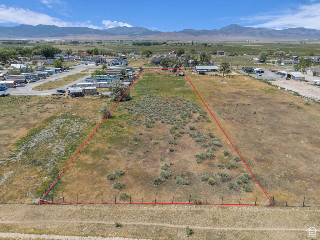 Aerial view of sparsely populated area featuring property parcel outlined and a mountainous background