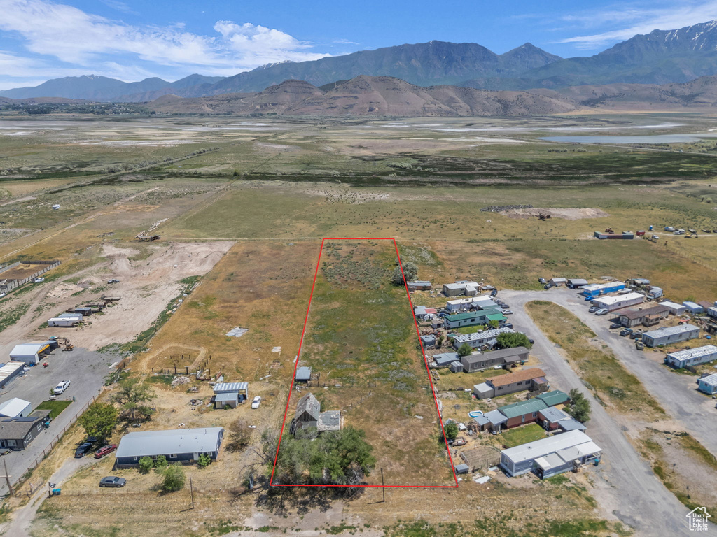 Aerial overview of property\'s location with property boundaries highlighted and a water and mountain view