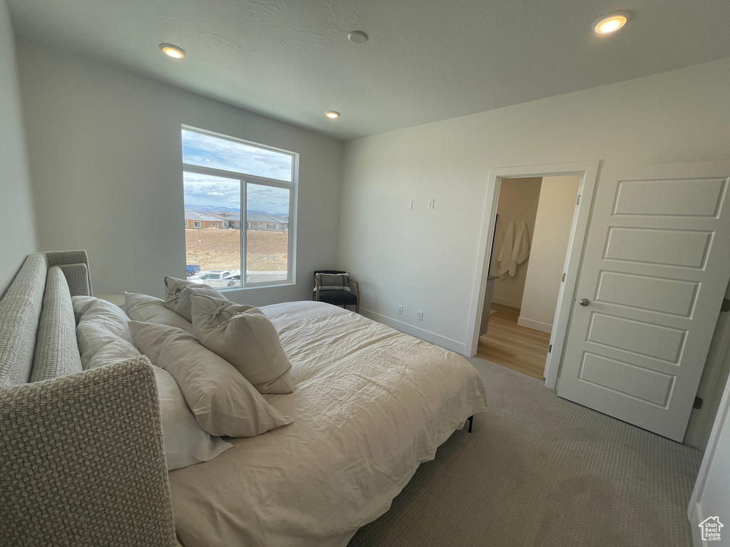 Bedroom featuring light colored carpet, recessed lighting, and baseboards