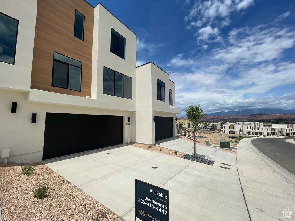 View of front facade with an attached garage, stucco siding, and concrete driveway