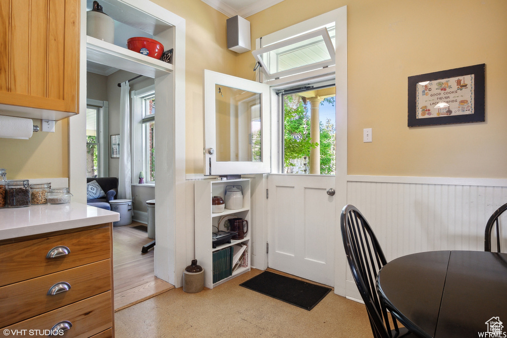 Entryway featuring a wainscoted wall and ornamental molding