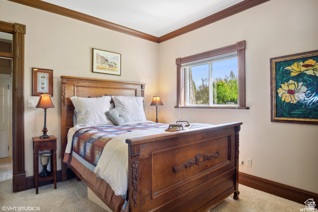 Bedroom featuring light carpet, crown molding, and baseboards