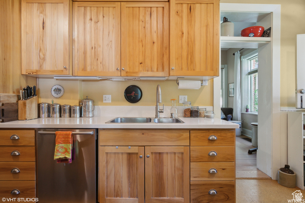 Kitchen with a sink, dishwasher, and light countertops