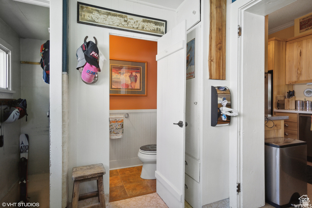 Bathroom featuring toilet and a wainscoted wall
