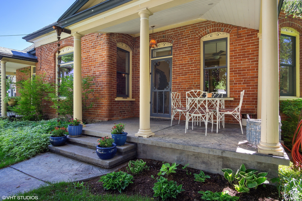 Entrance to property featuring covered porch and brick siding