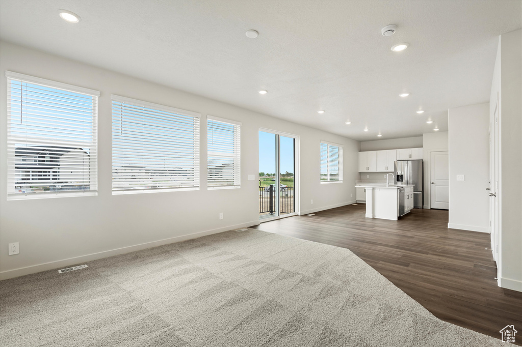 Unfurnished living room with recessed lighting and dark wood finished floors