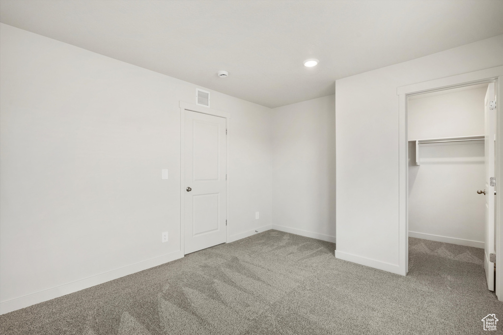 Unfurnished bedroom featuring carpet, a spacious closet, recessed lighting, and a closet