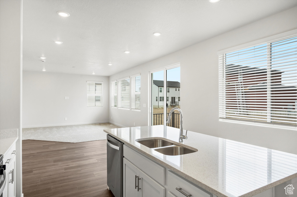 Kitchen with stainless steel dishwasher, open floor plan, recessed lighting, dark wood-style flooring, and an island with sink