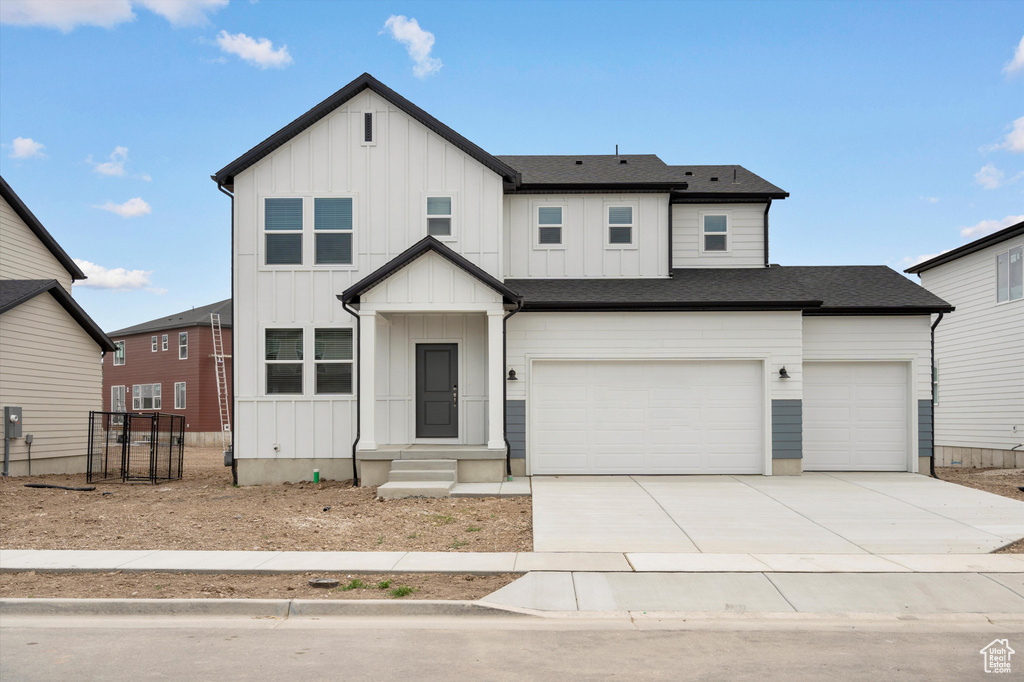 Modern farmhouse with board and batten siding, concrete driveway, an attached garage, and a shingled roof