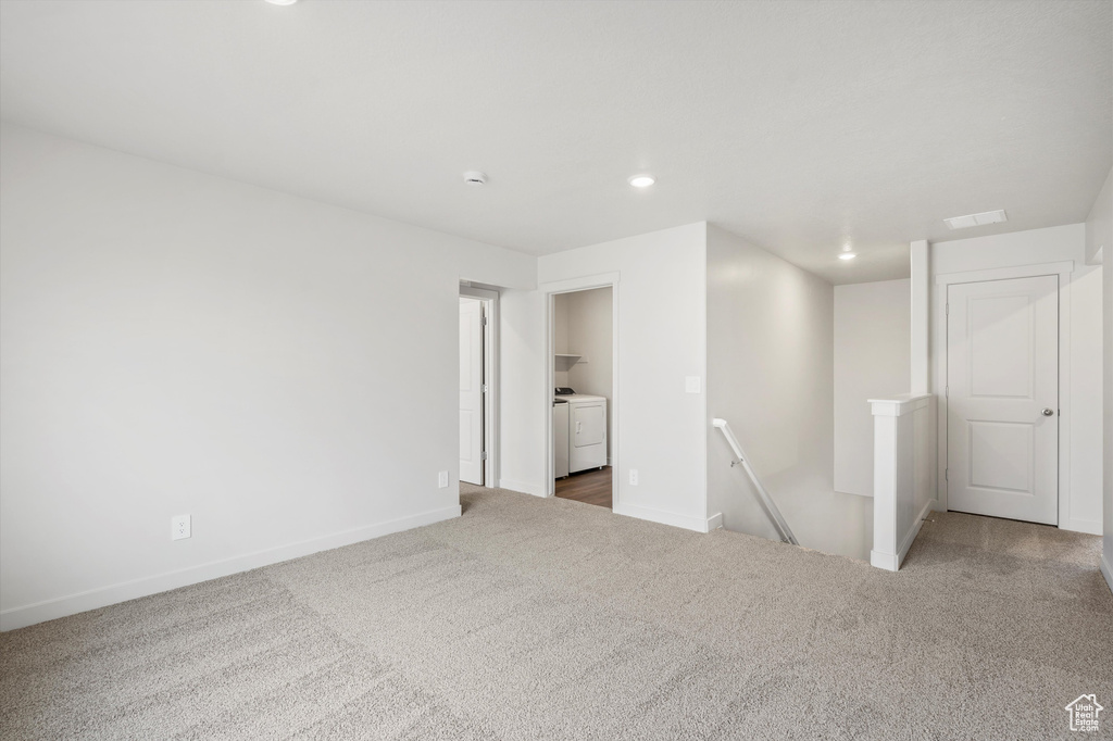 Carpeted empty room with washing machine and clothes dryer and recessed lighting