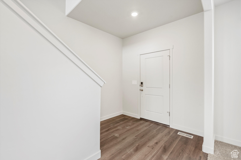 Entryway with wood finished floors and recessed lighting