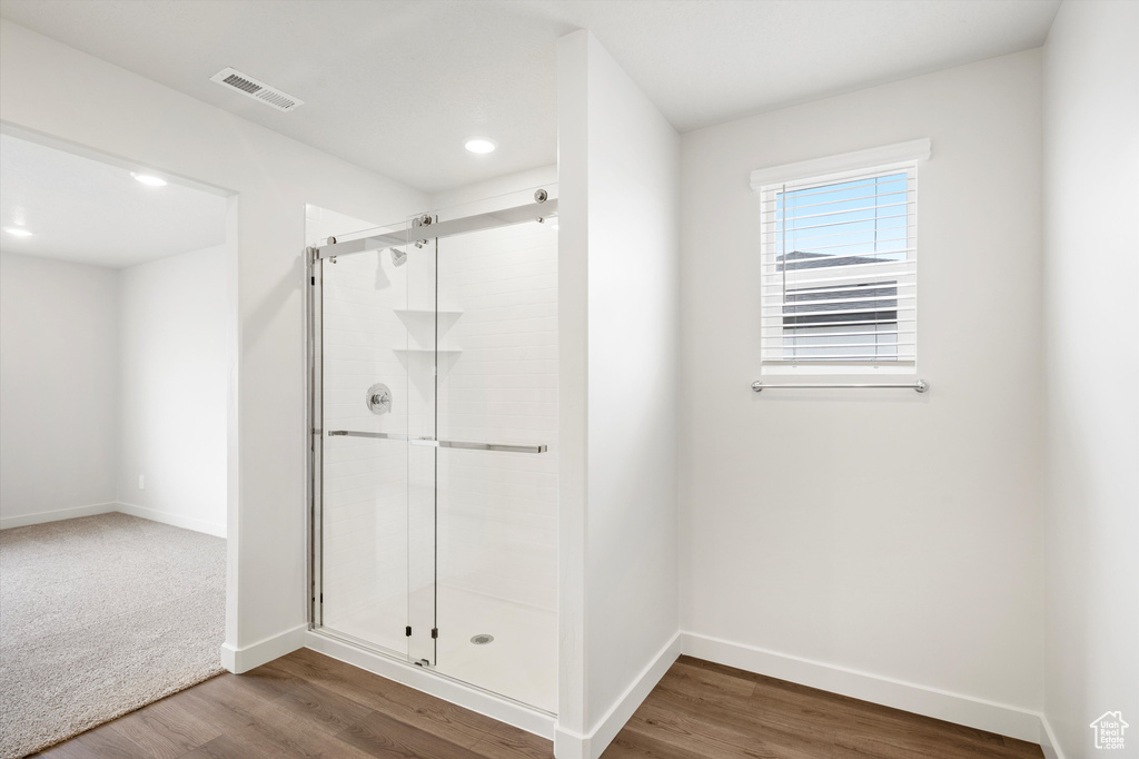 Bathroom featuring a shower stall, wood finished floors, and recessed lighting