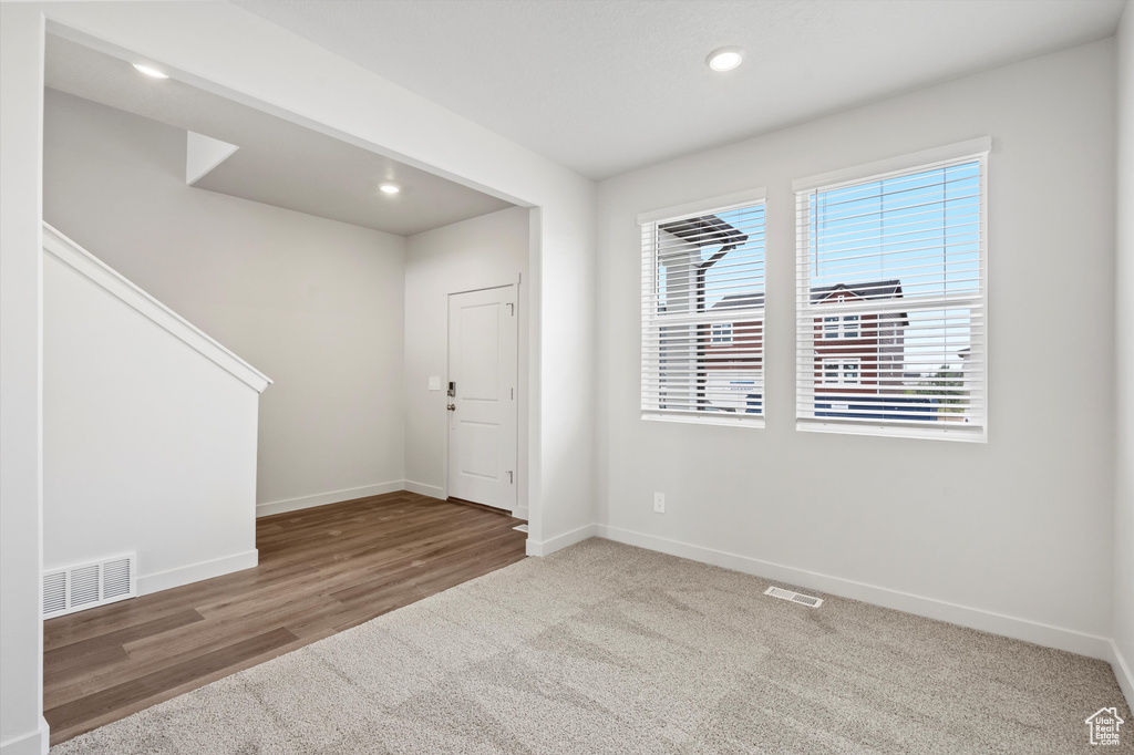 Carpeted empty room with recessed lighting and wood finished floors
