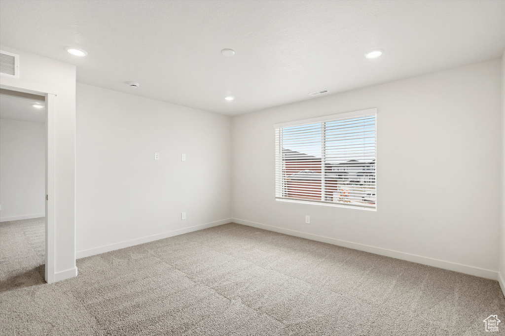 Carpeted spare room with recessed lighting and baseboards