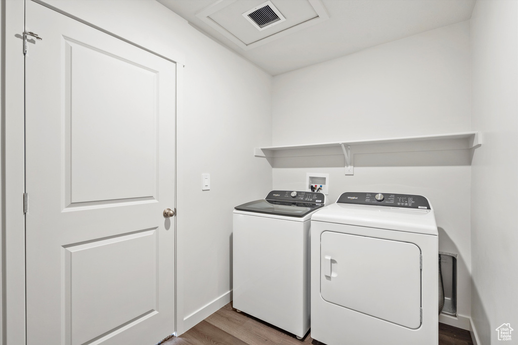 Laundry area featuring washing machine and dryer and wood finished floors