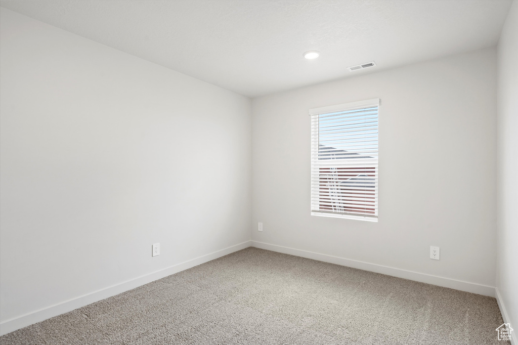 Unfurnished room with light colored carpet and recessed lighting