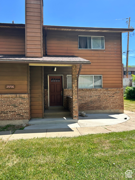 Entrance to property featuring a chimney and brick siding