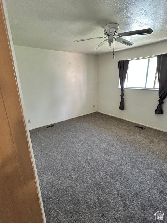 Unfurnished room featuring ceiling fan, a textured ceiling, and carpet flooring