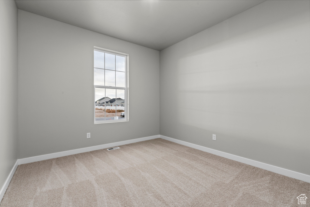 Empty room with carpet and baseboards