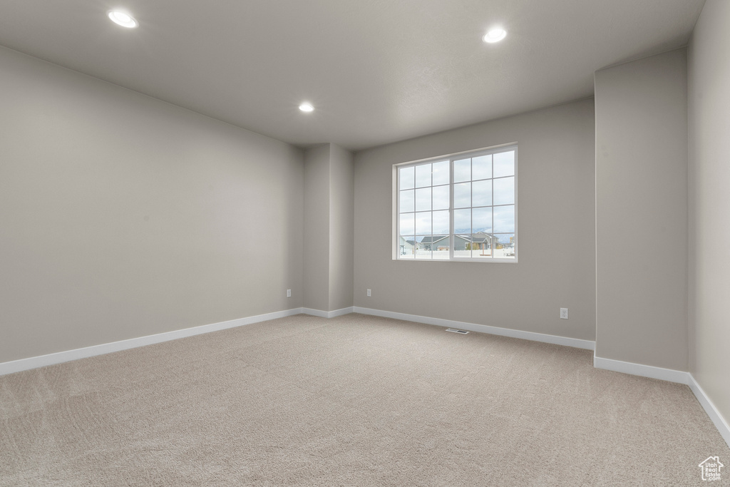 Spare room with recessed lighting, light carpet, and baseboards