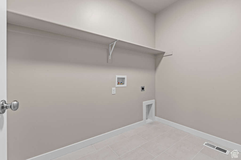 Washroom with hookup for a washing machine, hookup for an electric dryer, baseboards, and light tile patterned floors