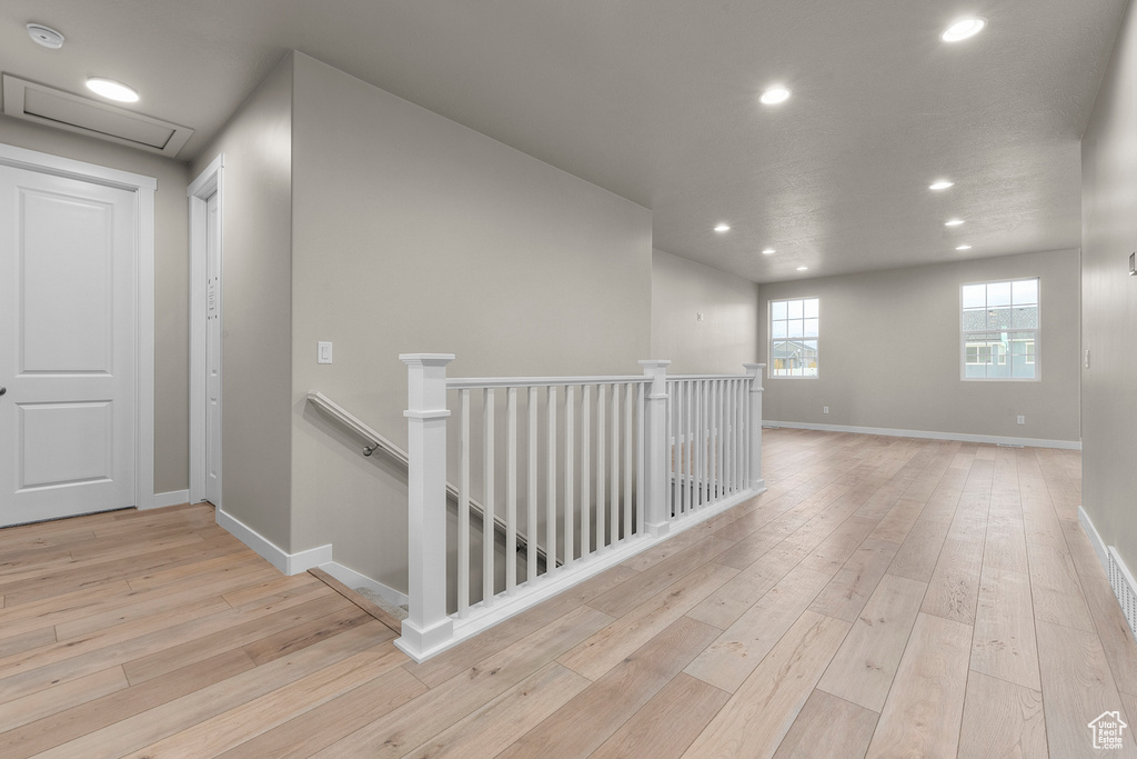 Hallway featuring an upstairs landing, recessed lighting, hardwood / wood-style floors, and baseboards