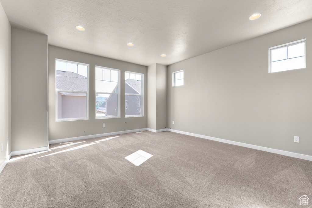 Carpeted spare room featuring recessed lighting and baseboards