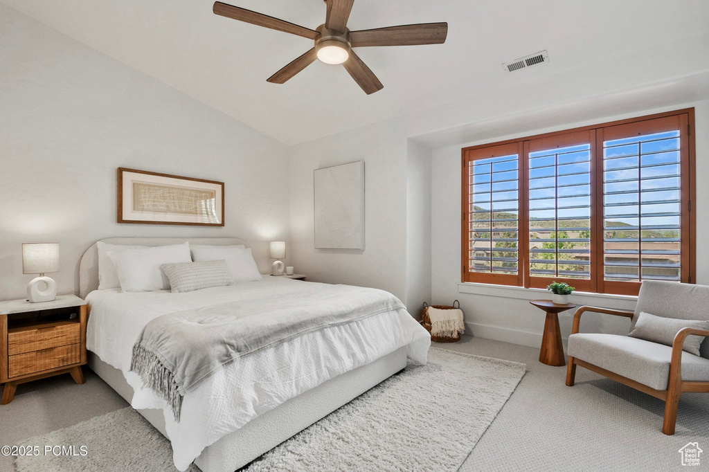 Bedroom with light carpet, vaulted ceiling, ceiling fan, and baseboards