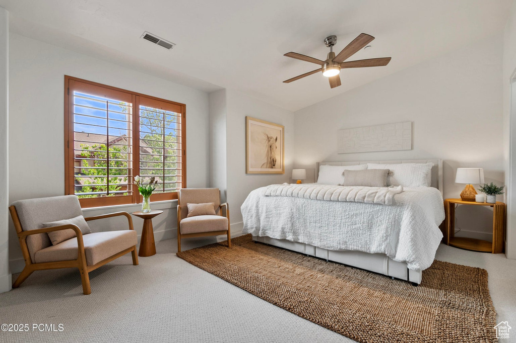 Bedroom with vaulted ceiling, carpet, and a ceiling fan