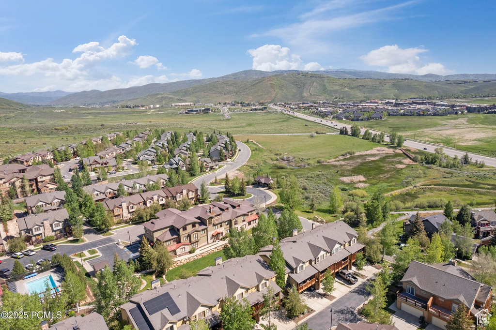 Aerial view of property and surrounding area with nearby suburban area and mountains