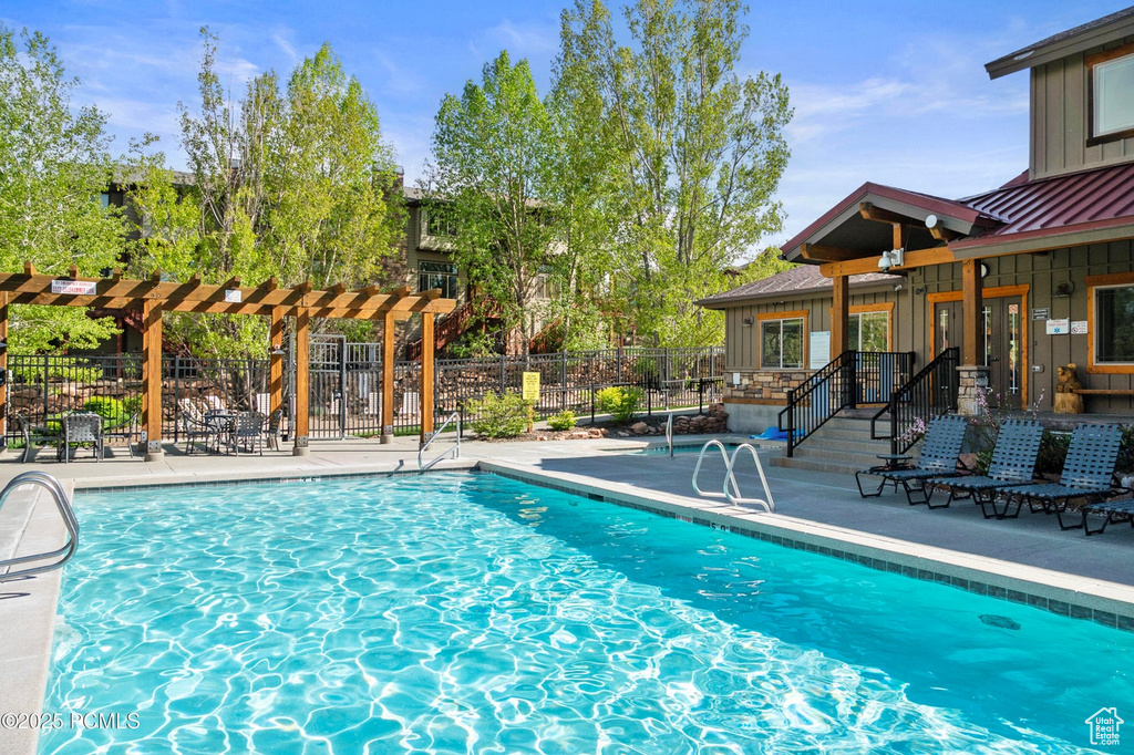 Community pool with a patio area and a pergola