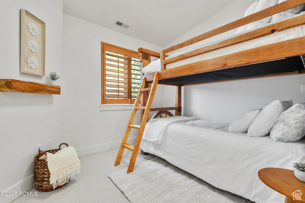 Bedroom with carpet flooring, vaulted ceiling, and baseboards