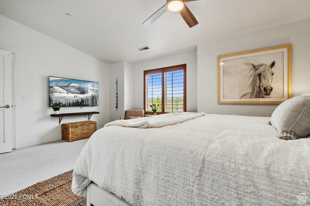 Carpeted bedroom with a ceiling fan, baseboards, and lofted ceiling