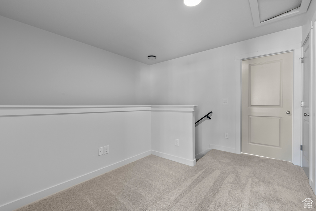 Spare room with carpet flooring, attic access, and baseboards