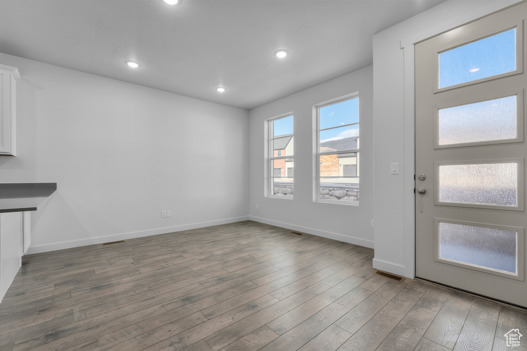 Unfurnished living room featuring wood finished floors, baseboards, and recessed lighting