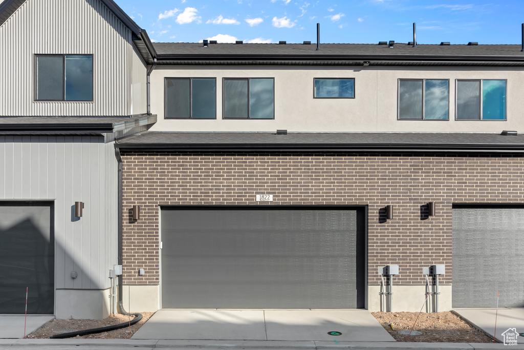 Back of property with brick siding and an attached garage
