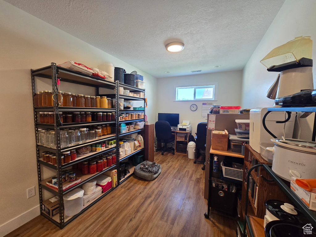 Office space featuring a textured ceiling, wood finished floors, and baseboards