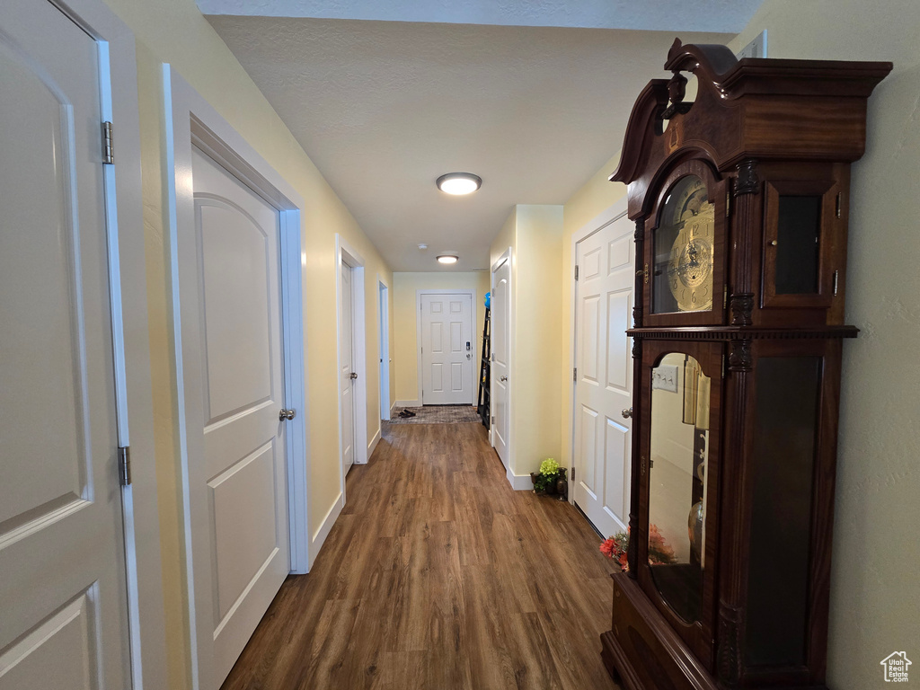 Corridor featuring baseboards and dark wood-style floors