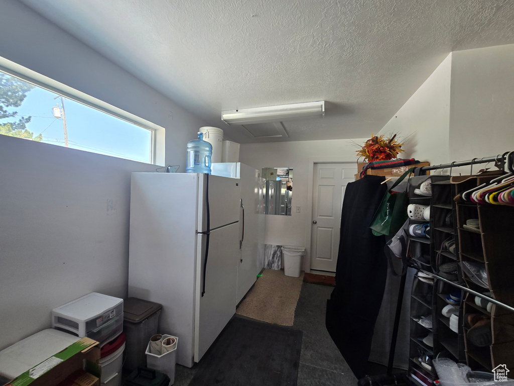 Kitchen featuring freestanding refrigerator and a textured ceiling