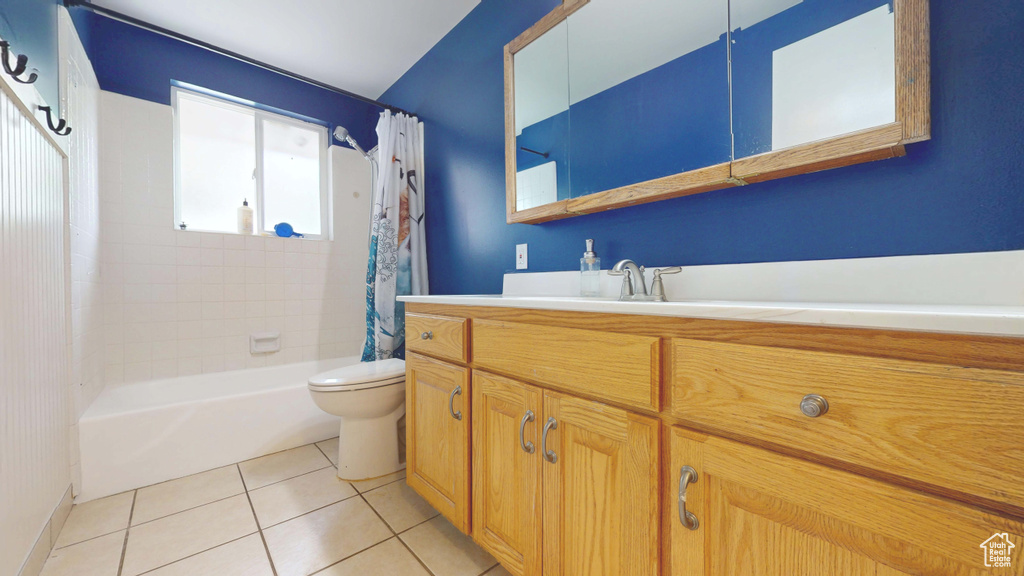 Bathroom with toilet, vanity, tile patterned flooring, and shower / bath combination with curtain