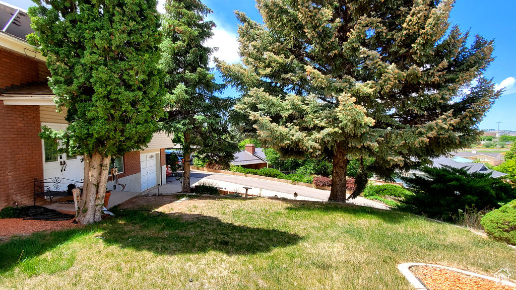 View of grassy yard featuring a garage