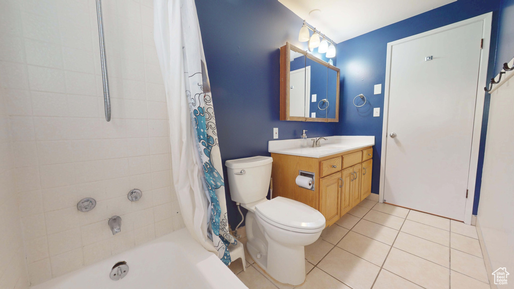 Bathroom featuring vanity, tile patterned flooring, toilet, and shower / tub combo