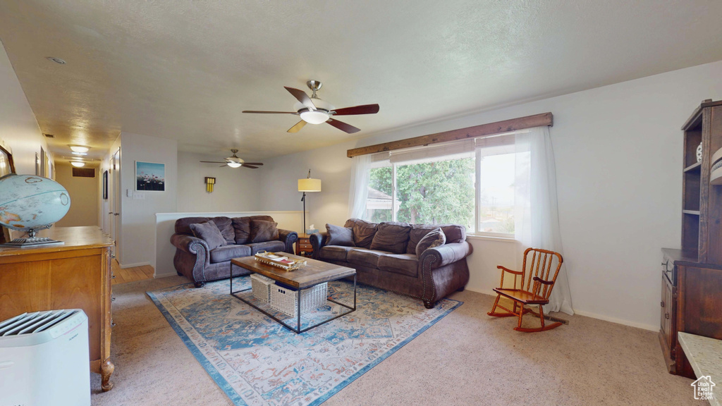 Carpeted living area with a ceiling fan