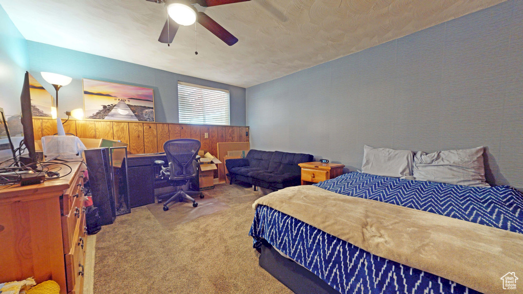 Carpeted bedroom with a desk and ceiling fan