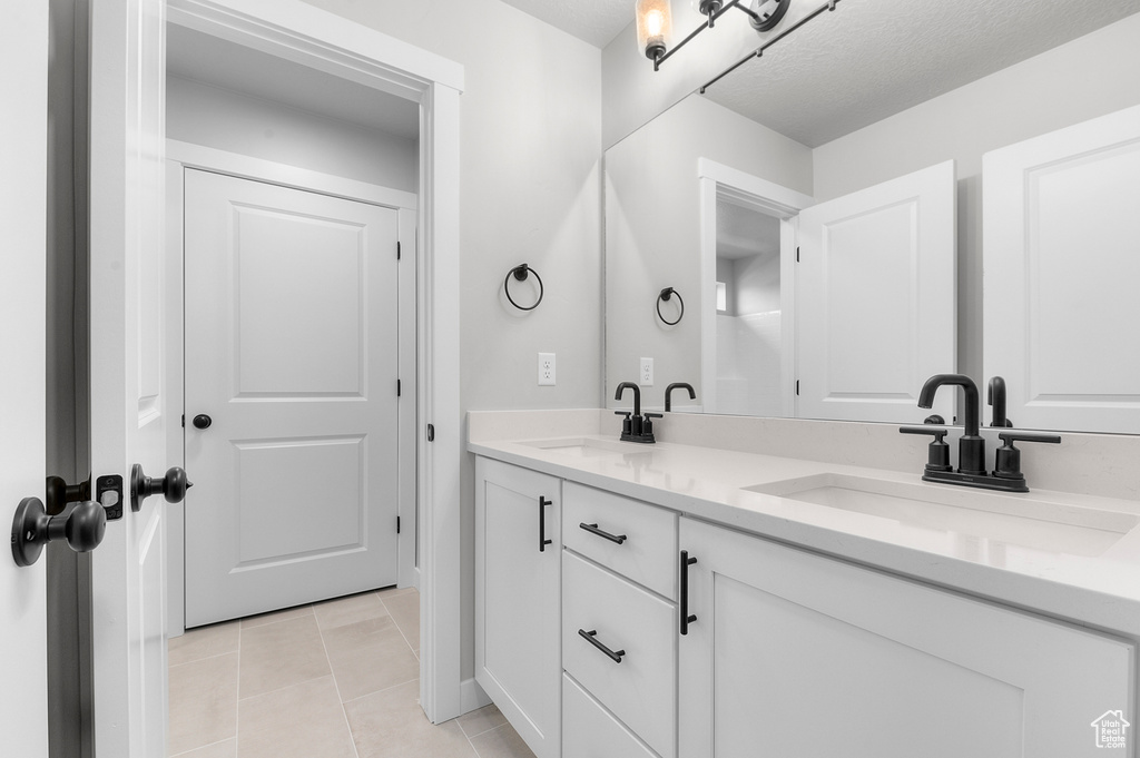 Bathroom with double vanity and tile patterned flooring