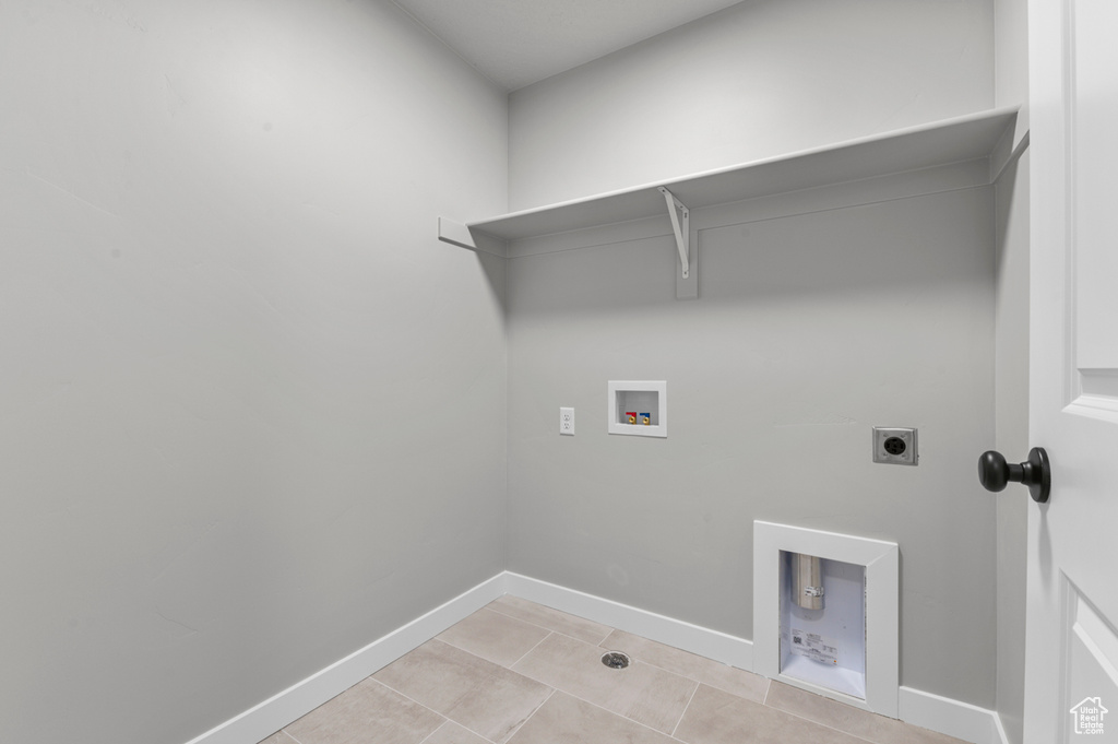 Laundry area featuring washer hookup, electric dryer hookup, baseboards, and light tile patterned flooring