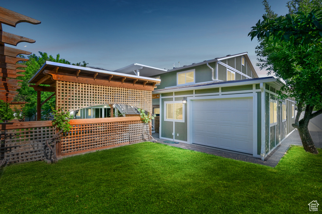 Back of property featuring a lawn and a garage